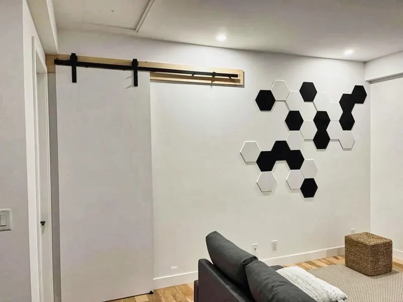 Salon aménagé avec porte de grange et mur décoratif d'hexagones